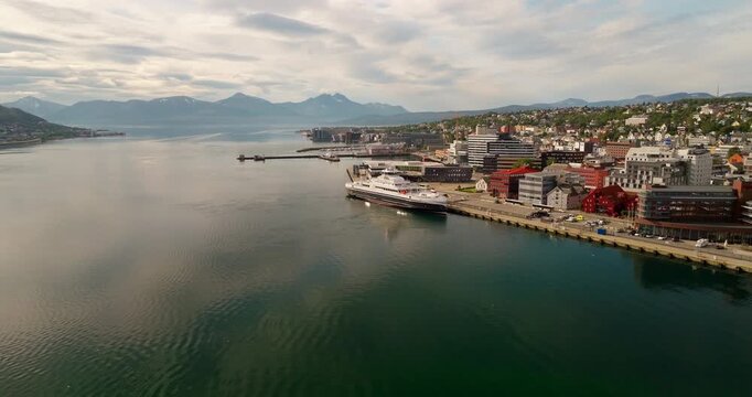 MF Hinn&oslash;y electric ferry docked on Tromso coastline in summer, aerial