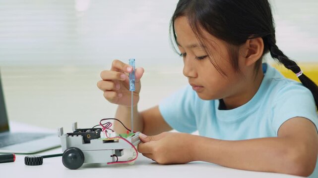 Young girl having fun working on a robot design