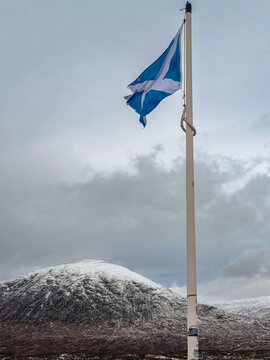 The scottish flag in the snowy mountains of Glencoe, Scotland UK.