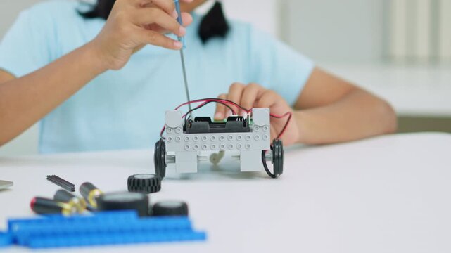 Young girl having fun working on a robot design