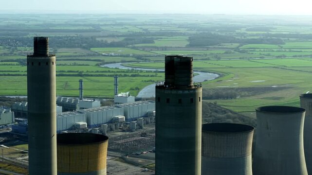 Aerial view of the West Burton Power Station, a decommissioned site with tall chimneys and cooling towers amid green fields, Retford, United Kingdom.