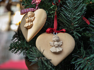 Fototapeta premium Wooden Heart Ornaments With Carved Angel Figures On Tree