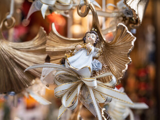 Fototapeta premium Golden Angel Ornament With White Bow On Christmas Tree, Bolzano, Italy
