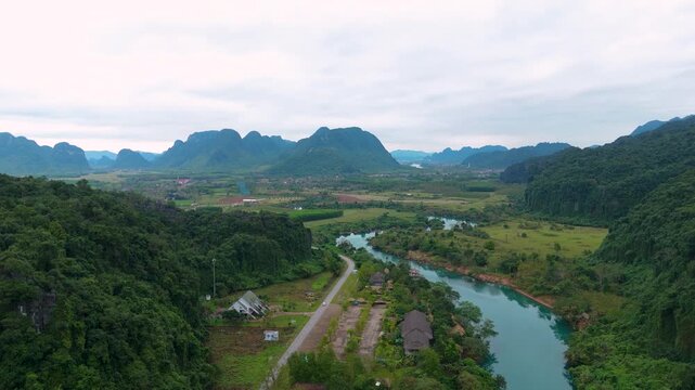 Aerial view of the Dark Cave, Phong Nha, where emerald rivers meander through lush green landscapes against a backdrop of towering mountains, Dark Cave, Qung Binh, Vietnam.