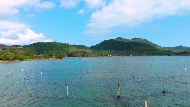Aerial view of the Oyster Farm with clear turquoise water and green mountains in the background, tt. Lang Co, Hue, Vietnam.