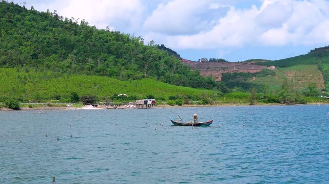 Aerial view of a lone figure on a boat stands out against the tranquil waters near the Oyster Farm, tt. Lang Co, Hue, Vietnam.