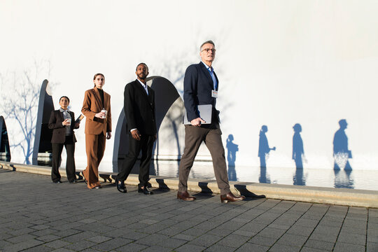 Business team walking in a row outside convention center