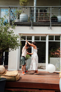 Mother and son with trisomy 21 dancing together outdoors on patio