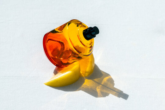 Vibrant luxury citrus perfume bottle with lemon and colorful shadow