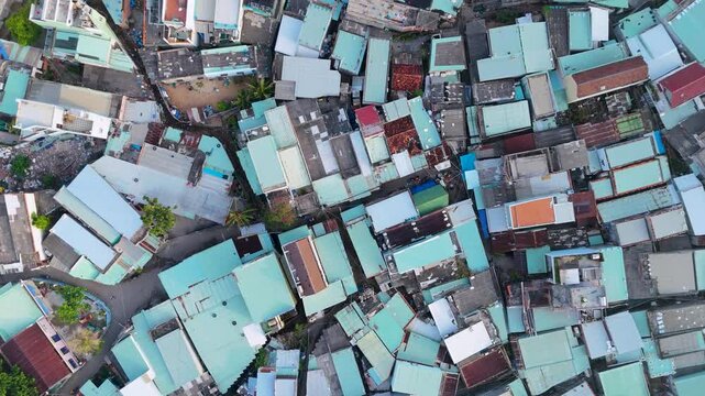 Aerial view of clustered buildings with turquoise roofs creating a mosaic-like pattern, displaying the urban landscape, Bai Xep Beach, Binh Dinh, Vietnam.
