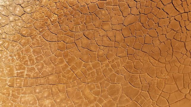 Aerial view of cracked red earth and dry mud patterns in the mining landscape of Minas de Riotinto, Andalusia, Spain.