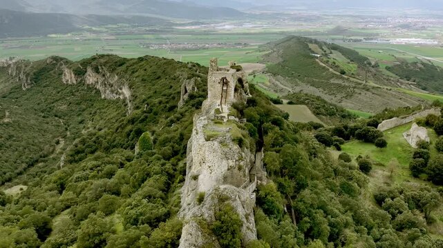  Vista a&eacute;rea cinematogr&aacute;fica de una fortaleza medieval en ruinas sobre un escarpado risco, con muros de piedra dominando el paisaje y evocando historia y car&aacute;ct