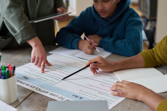 Students listening to teacher explaining grammar rules at group class