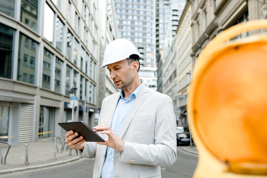 Engineer in construction helmet using tablet outdoors in Frankfurt