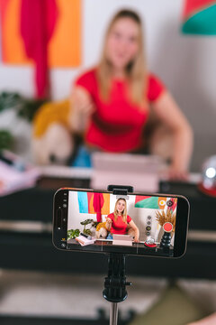 Content creator filming vocal lesson at home studio with smartphone