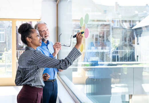 Business colleagues brainstorming with sticky notes in modern office