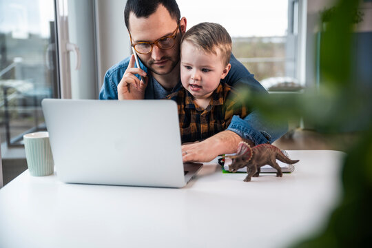Father and son working and playing together at home office