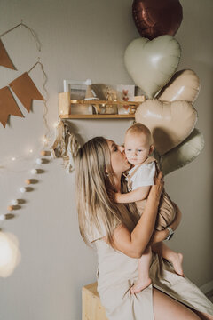Mother hugging and kissing child on first birthday celebration
