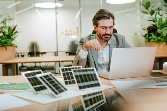 Businessman working on a sustainability project with solar panels in an office
