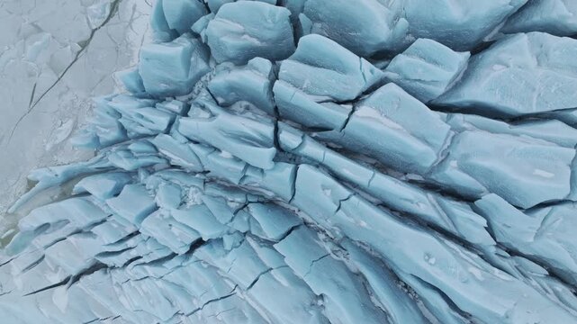 Aerial view of the deep blue crevasses and cracked ice textures of the Jokulsarlon glacier lagoon in Jokulsarlon, Sveitarfelagid Hornafjordur, Iceland.