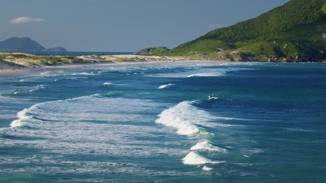 Santinho beach with people relaxing near the water. Florianopolis, Brazil