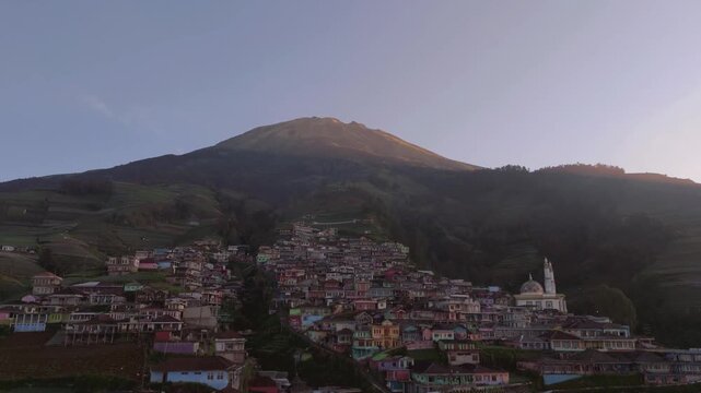 Aerial view of the settlement with colorful houses cascading down the slopes of Mount Sumbing, creating a vibrant contrast against the mountain, Indonesia van Java, Mount Sumbing, Indonesia.