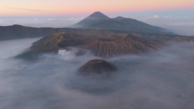 Aerial view of Mount Bromo and surrounding peaks piercing through a sea of ethereal mist at sunrise, Bromo Tengger Semeru National Park, East Java, Indonesia.