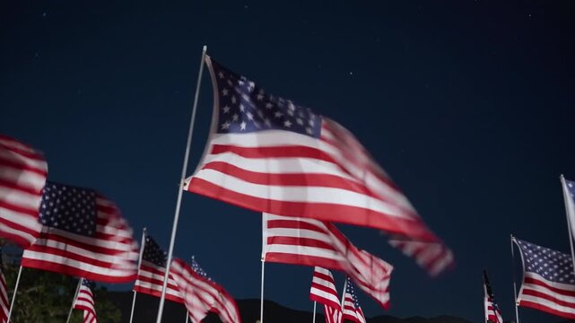 Close waving USA flag at night in Malibu, California, USA under strong lighting, creating high contrast patriotic and emotional memorial atmosphere