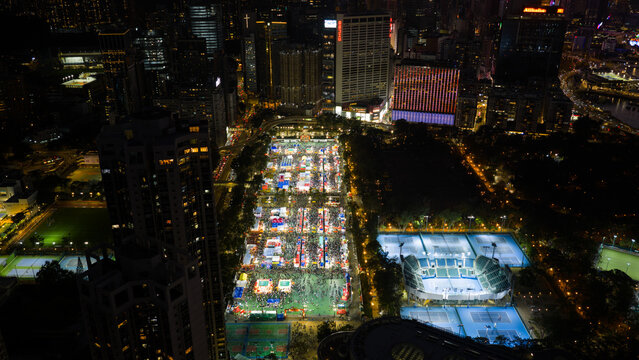 Hong Kong - 14 February 2026: Aerial view of Victoria Park during a night fair with illuminated stalls, tennis courts, and surrounding skyscrapers.