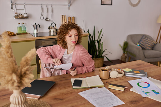 Curly woman enjoys creative moments at home in spring time comfort