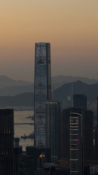 Hong Kong - 14 February 2026: Aerial view of the International Commerce Centre skyscraper and Victoria Harbour with mountains under a sunset sky.