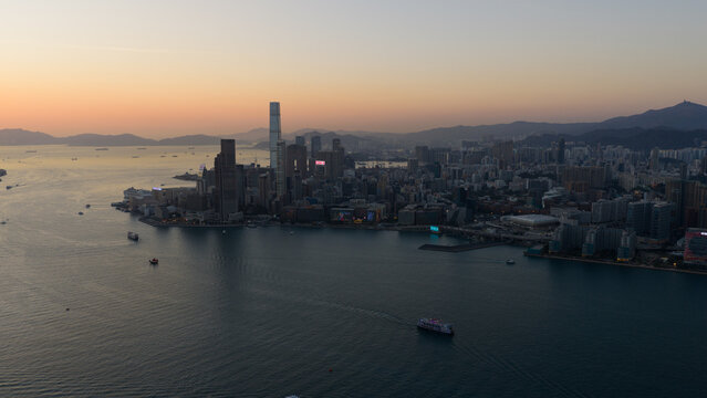 Hong Kong - 14 February 2026: Aerial view of Victoria Harbour and the Kowloon skyline featuring the International Commerce Centre at sunset with boats on the water.