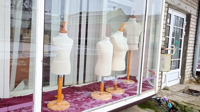 Identical mannequins behind glass, symbolize conformity and lost identity