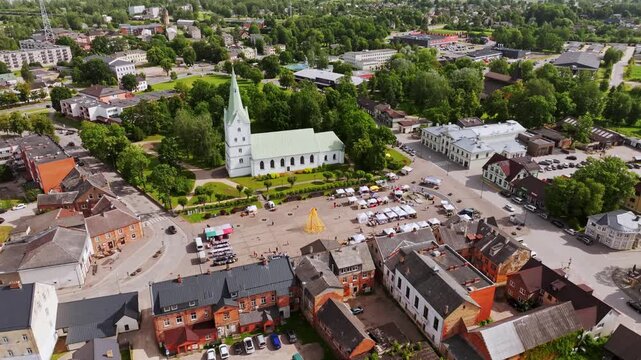 Aerial view of small town Dobele with church and square under cloudy sky