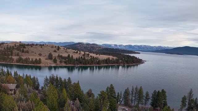 Aerial view of Wild Horse Island surrounded by Flathead Lake with forested shoreline and distant mountain ranges near Kalispell, Montana
