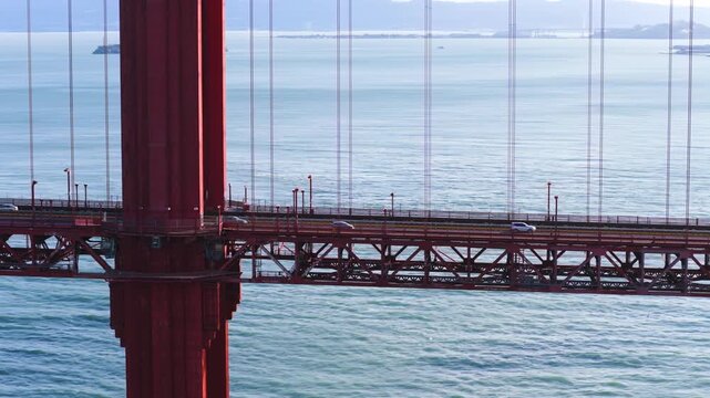 Close-up Of Golden Gate Bridge With Vehicles Driving. Alcatraz Island In Hazy Distance. sideways drone shot