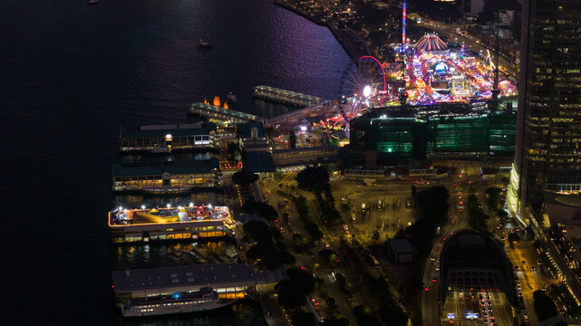 Hong Kong - 13 February 2026: Aerial view of the Hong Kong Observation Wheel and AIA Vitality Park carnival at night with illuminated piers and city lights along Victoria Harbour.