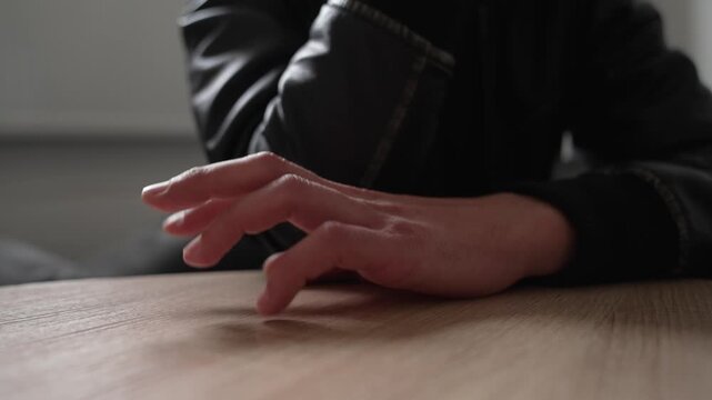 Close up of a male hand nervously tapping his fingers on the table. hand gesture. Man waiting and knocks his fingers on the table.