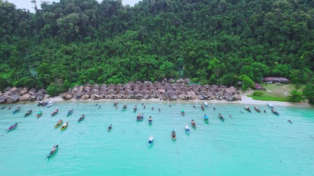 Aerial view of Moken village at Surin Islands National Park with wooden longtail boats in turquoise sea water