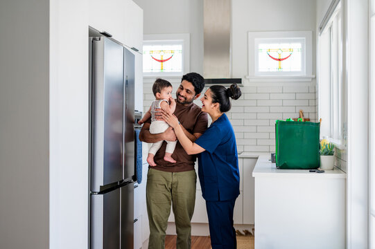 Family spending a warm moment in the kitchen with one parent holding their child