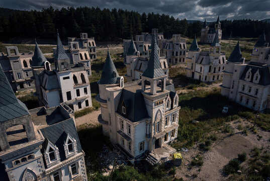 View of Burj Al Babas abandoned castle-style villas with pointed turrets and grey roofs nestled against a dense pine forest under dramatic clouds Dolayuz, Bolu, Turkey.