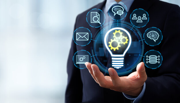 Knowledge management and business intelligence sharing. Knowledge base and enterprise search tool. Businessman holding lightbulb and gear icons.