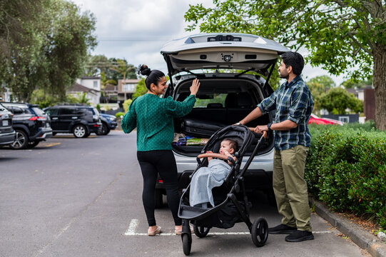 Parents ready for a stroller after buckling their child in a stroller