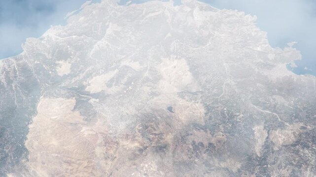 Flying over Dalyan Turkey Mediterranean coastline satellite view from space with passing clouds based on Nasa imagery