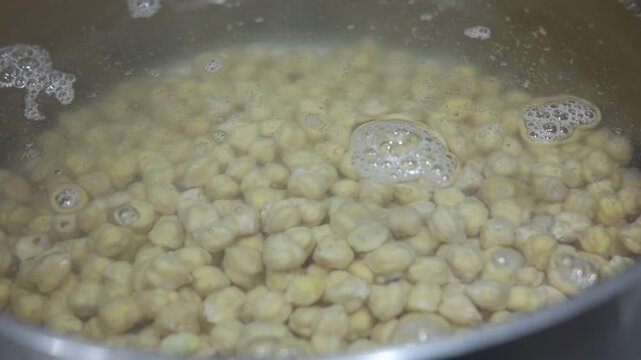 Chickpeas boiling in bubbling water, soaking up moisture before cooking