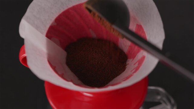 Pouring freshly ground coffee into V60 dripper from above