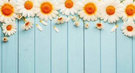 Fototapeta premium A vibrant floral arrangement of sunflowers and daisies against a light blue wooden background