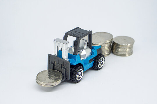 Toy Forklift Lifting Silver Coins Symbolizing Financial Growth and Economic Wealth Management
