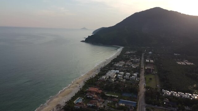 Aerial 4K view of Maresias beach coastline and village surrounded by mountains in Brazil
