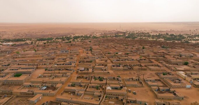 Ancient Desert Settlement Of Ouadane, Mauritania, With Mud-brick Buildings And Walled Courtyards. aerial orbiting shot